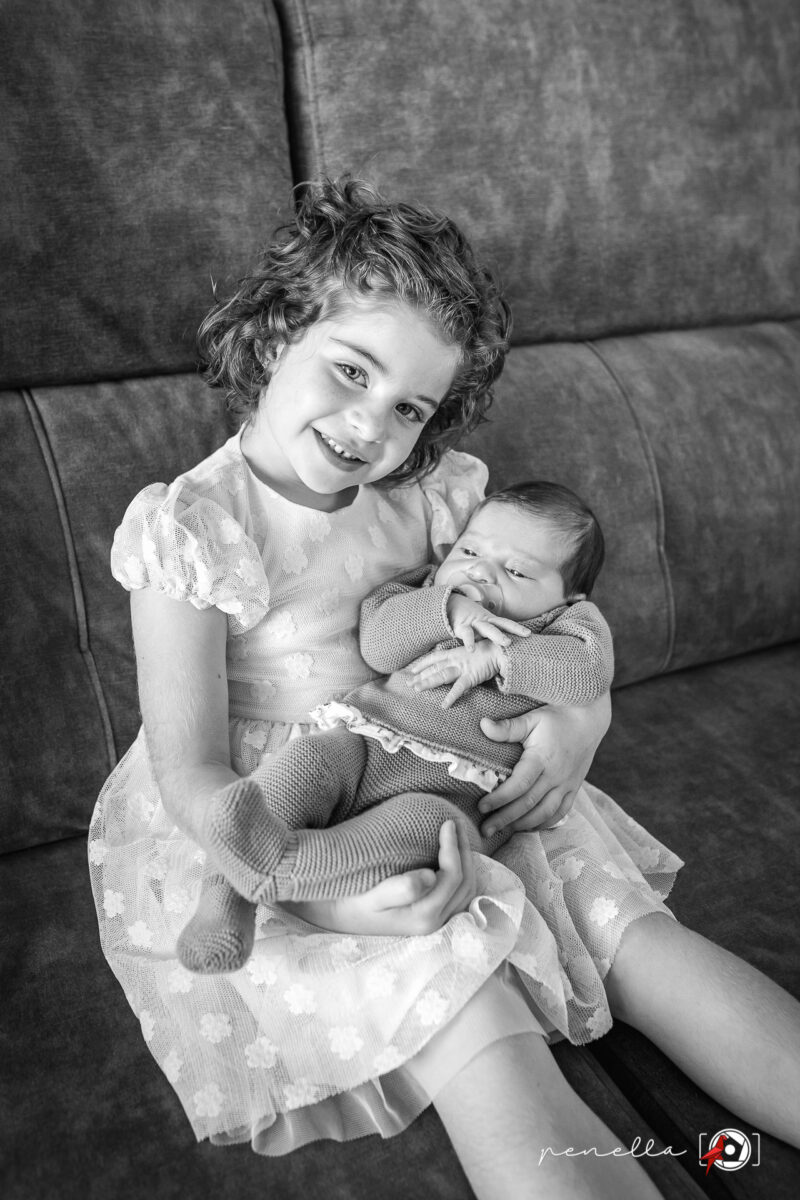 Foto de las hermanas en su sofá a los pocos días de nacer, sesiones lifestyle a domicilio