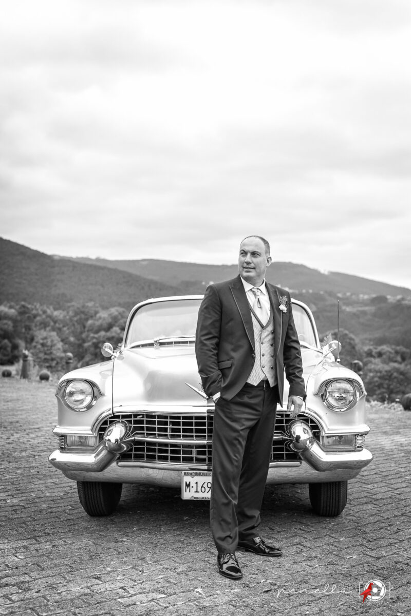 Foto del novio con el coche Cadillac el día de su boda en Soto del Barco