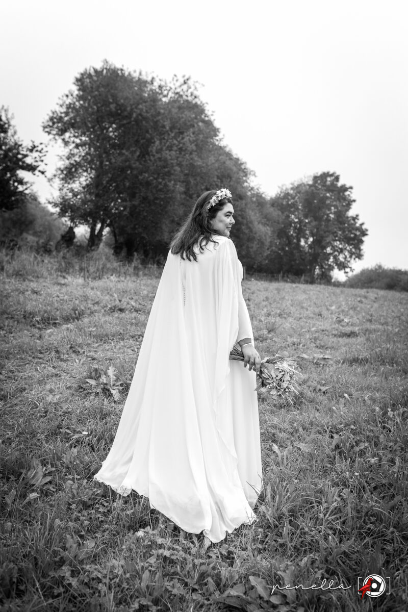 Retrato de la novia con su vestido con capa en el prado de su familia en Grado en Asturias